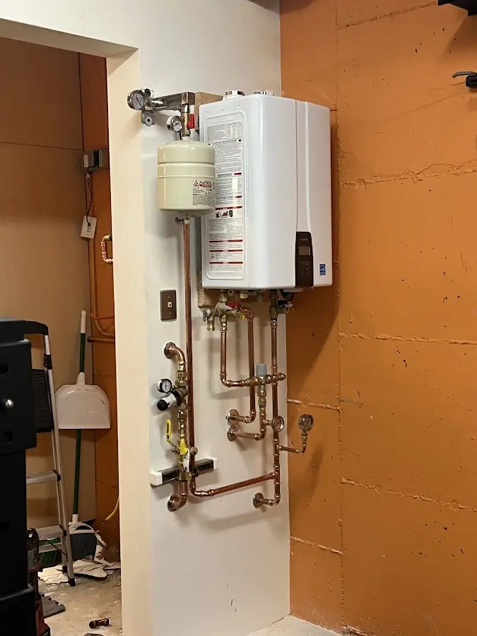 Plumbing technician inspecting water heater connections in Litchfield Beach